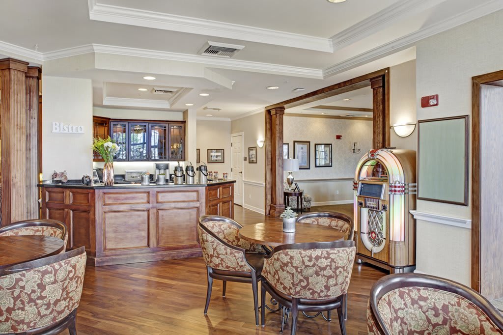 A cozy dining area featuring classic wooden furniture and a vintage jukebox.