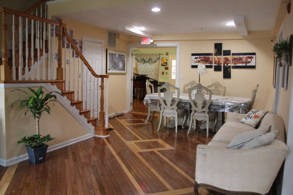 A spacious living and dining area with hardwood flooring and elegant furnishings.
