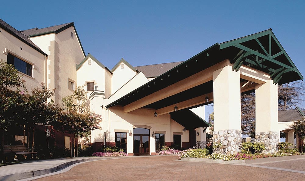 The exterior entrance of a hotel with a covered driveway.