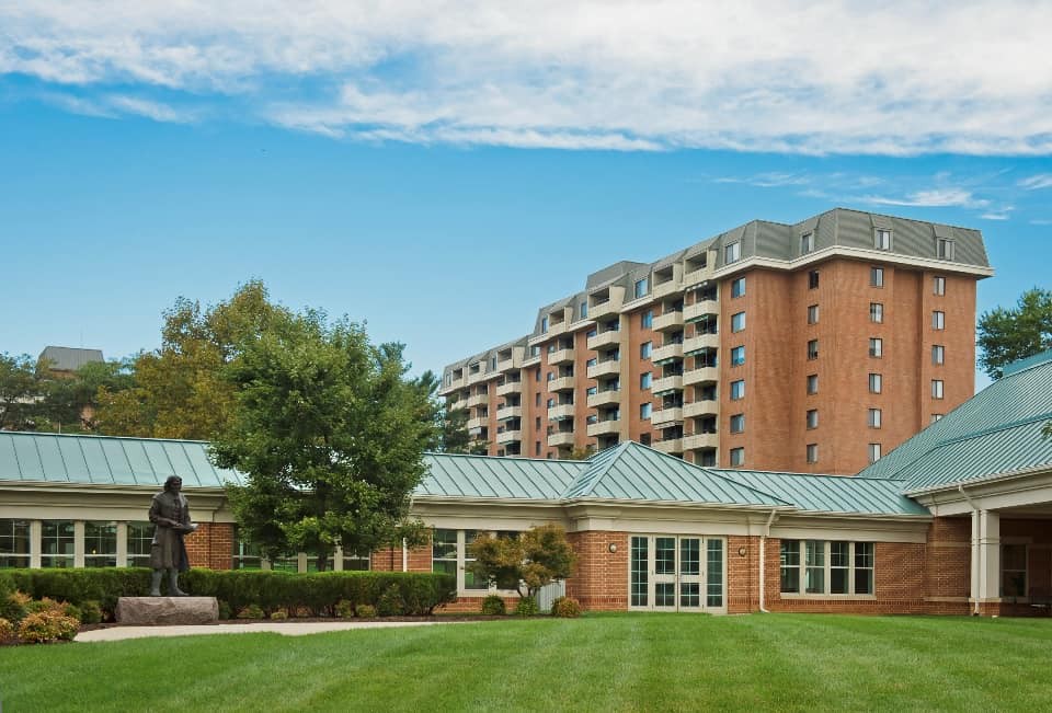 A residential building with a well-maintained lawn and trees.