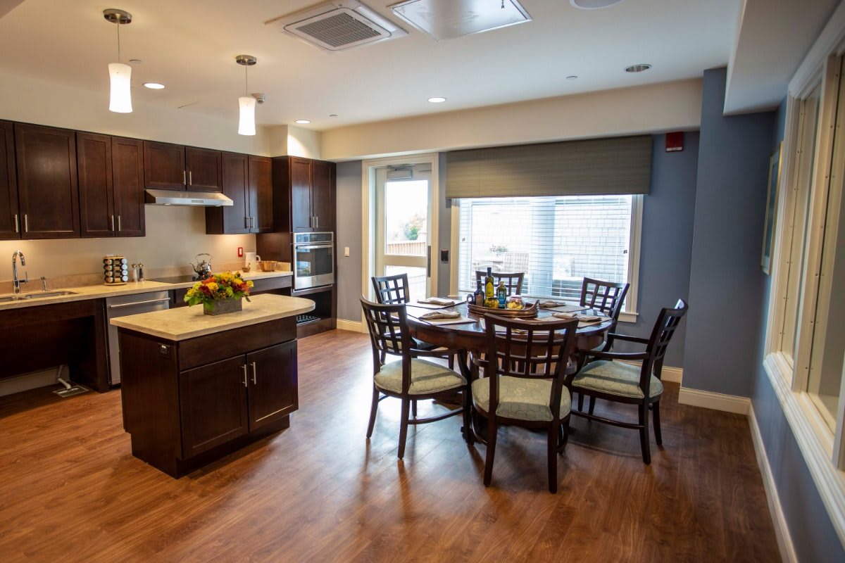 A modern kitchen and dining area with wooden flooring and elegant furniture.