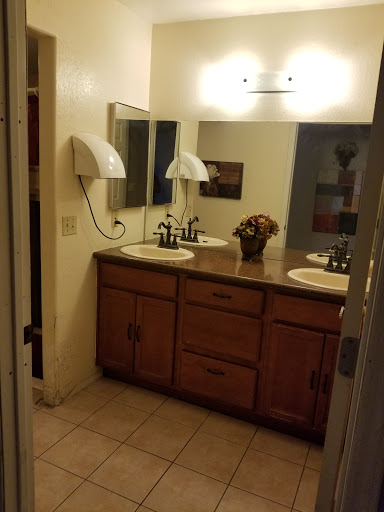 A spacious bathroom featuring a double vanity with wooden cabinets and decorative elements.