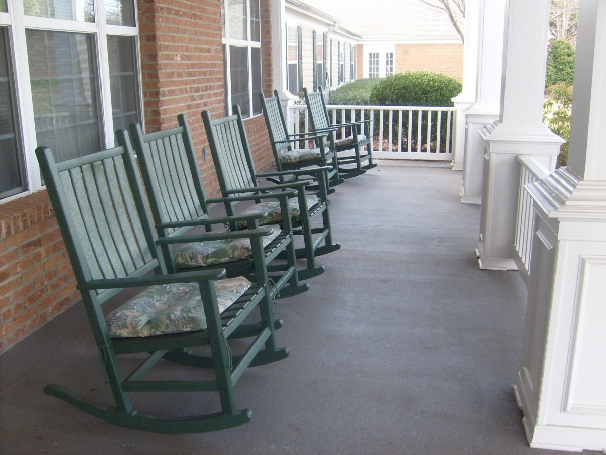 A row of rocking chairs lined up on a porch, perfect for relaxation.