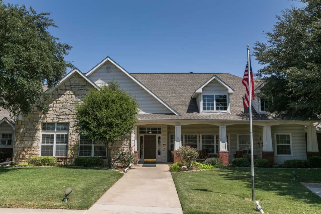 A suburban house with a well-maintained lawn and an American flag.
