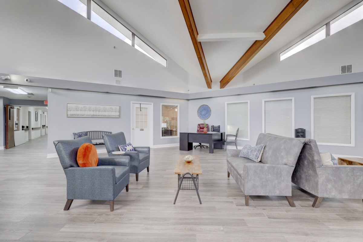 A spacious, modern living room with gray sofas and wooden beams.