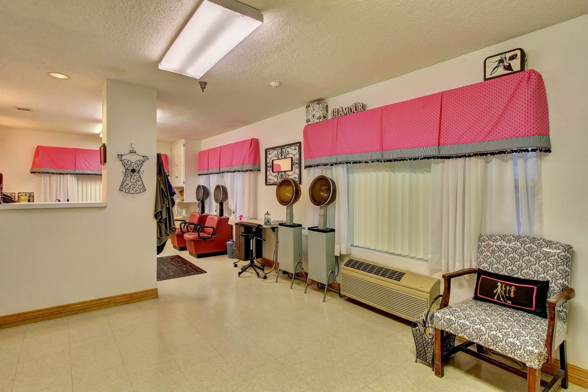A vintage salon with retro design featuring pink decor and classic hair dryers.