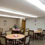 A cozy dining area with round tables, chairs, and wall decorations.