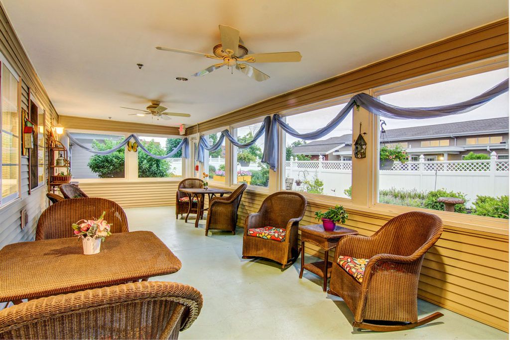 A cozy indoor lounge area with wicker furniture and ample natural light.