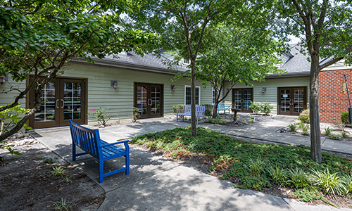 A tranquil garden area with benches and trees outside a building.