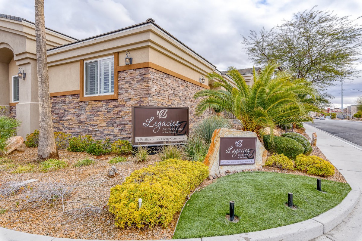 A well-maintained residential building with a prominent entrance sign and landscaped surroundings.