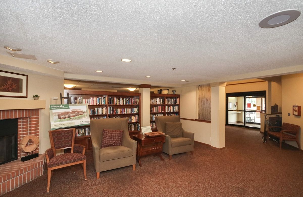 A cozy reading nook with comfortable chairs and shelves filled with books.