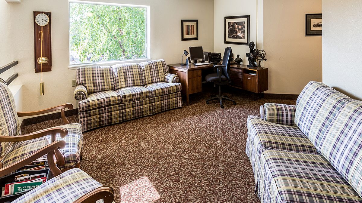 A cozy office space with plaid furniture and a desk setup.