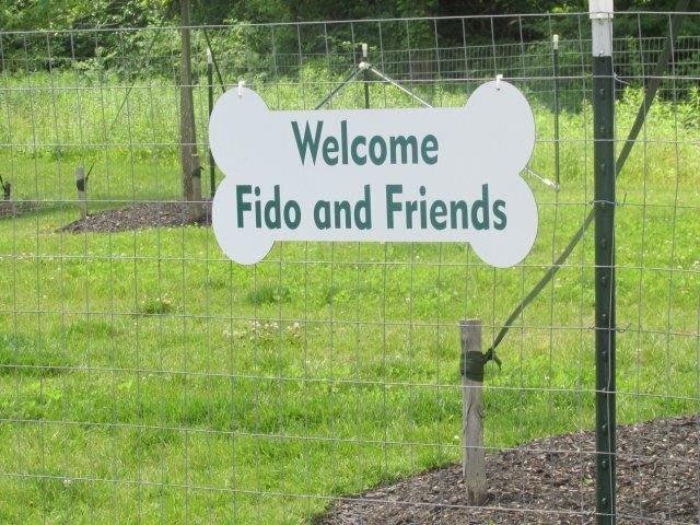 A welcome sign for 'Fido and Friends' at a dog park.
