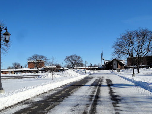A serene winter scene featuring a snow-covered road under a clear blue sky.