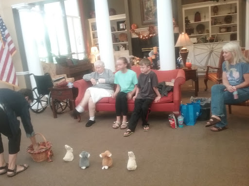A family gathering in a cozy living room, with children sitting on the couch and engaging in an activity.