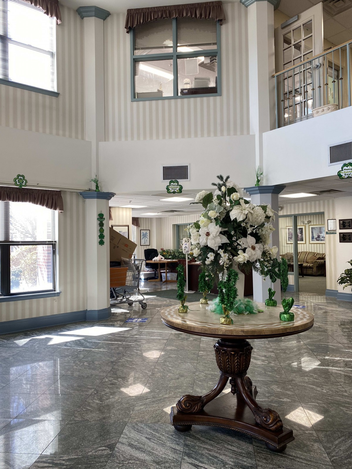 A bright and welcoming lobby with a floral arrangement on a central table.