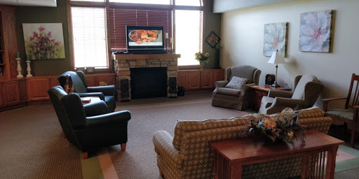 A cozy living room featuring comfortable seating and a television above the fireplace.