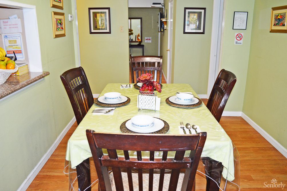 A neatly set dining table with four chairs in a home interior.