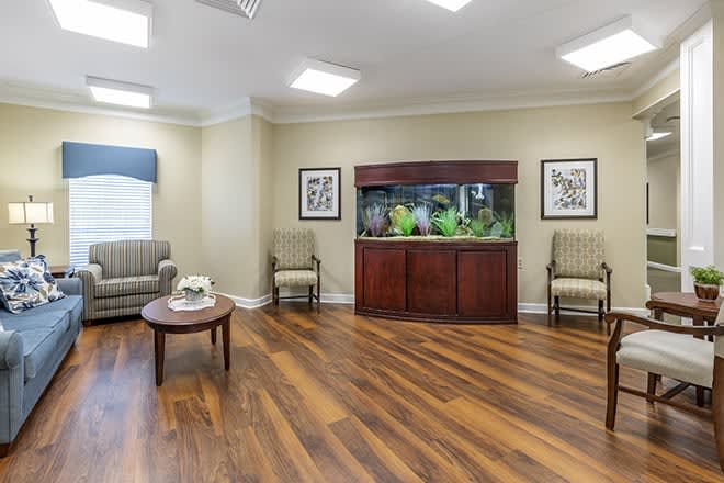 A well-lit waiting room with an aquarium and comfortable seating.