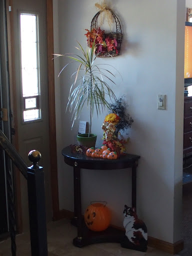 A cozy entryway decorated for Halloween with autumn elements.