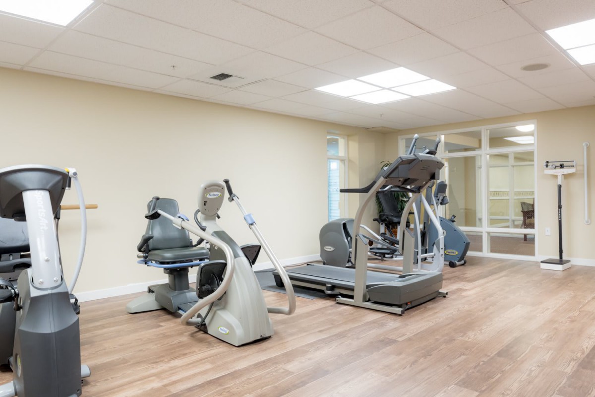 A modern gym with exercise equipment, including elliptical machines.
