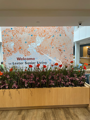 A welcoming display at Lester Senior Living with vibrant flowers and a decorative wall.