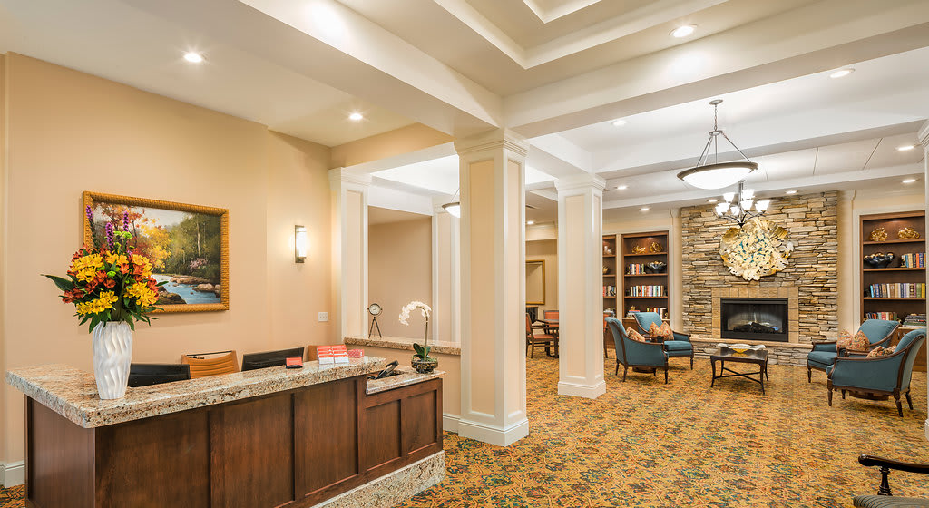 A warmly lit hotel lobby with a reception desk and comfortable seating area.