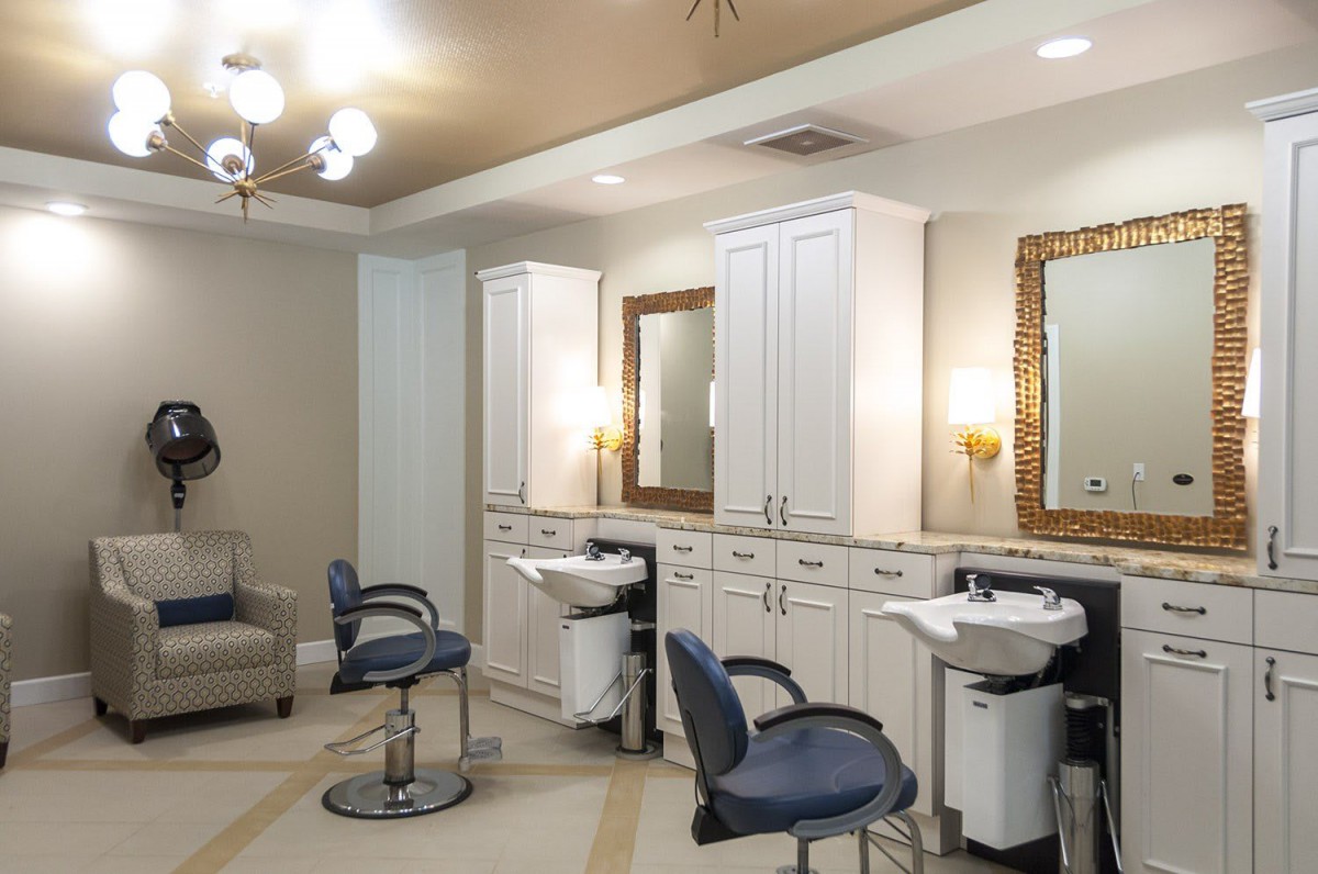 A modern hair salon interior with styling chairs, mirrors, and sinks.