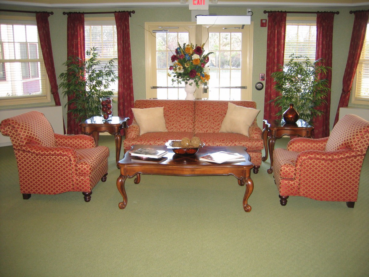 A cozy living room with a classic sofa set, a wooden coffee table, and vibrant decor.