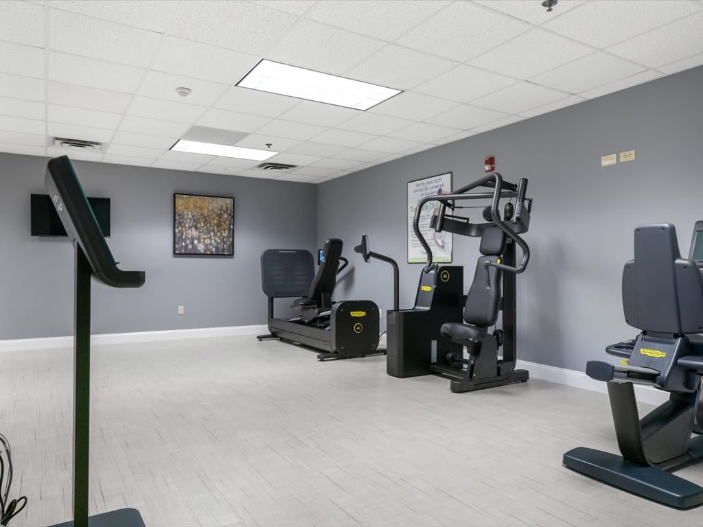 A gym featuring various exercise machines in a clean, well-lit space.