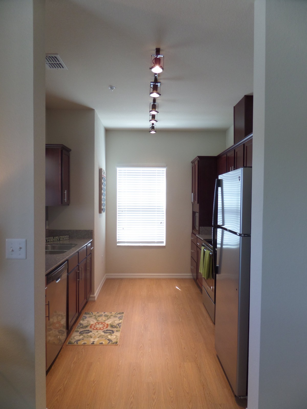 Bright galley kitchen with wooden floors and modern appliances.