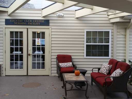A cozy outdoor seating area with red chairs and a small table, perfect for relaxing.