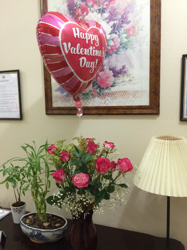 A festive Valentine's Day setup with pink roses and a cheerful balloon.