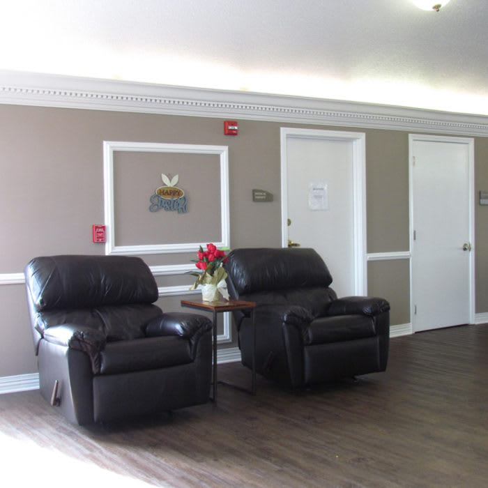 A cozy waiting area with leather chairs and a small table.