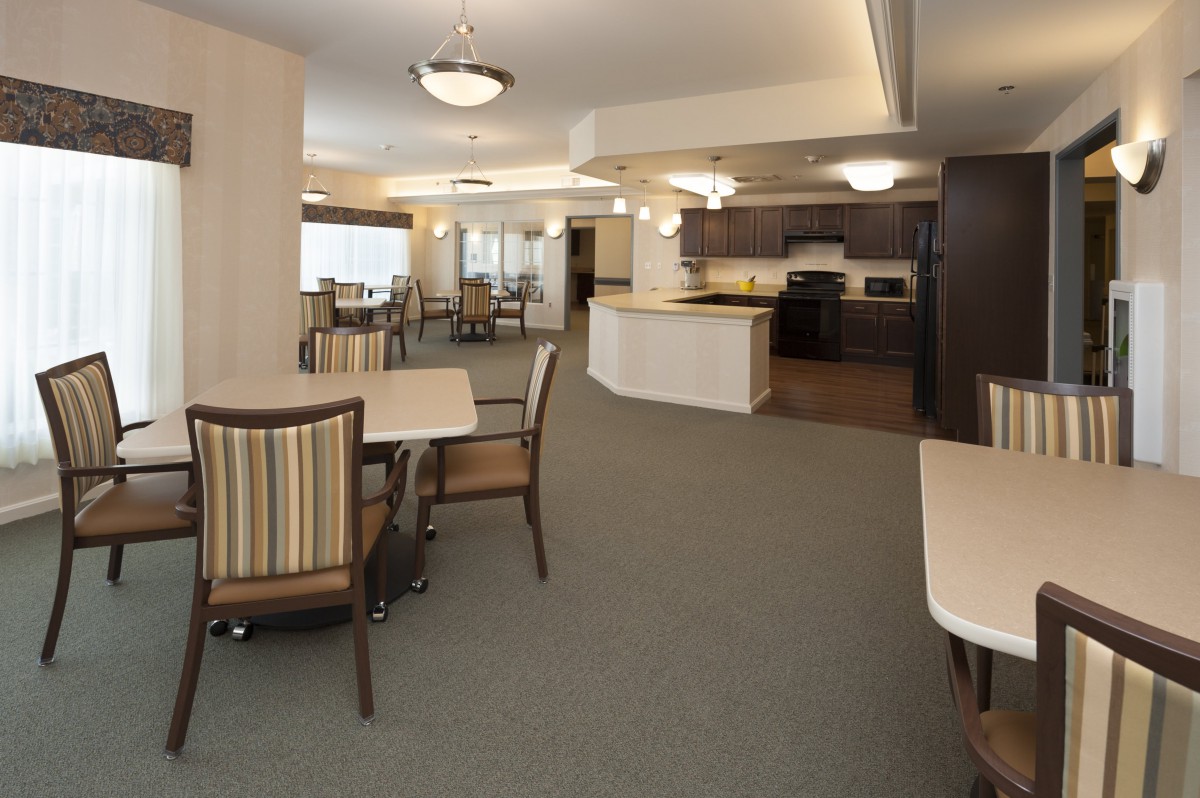 A modern open-concept kitchen and dining area with tables and chairs.