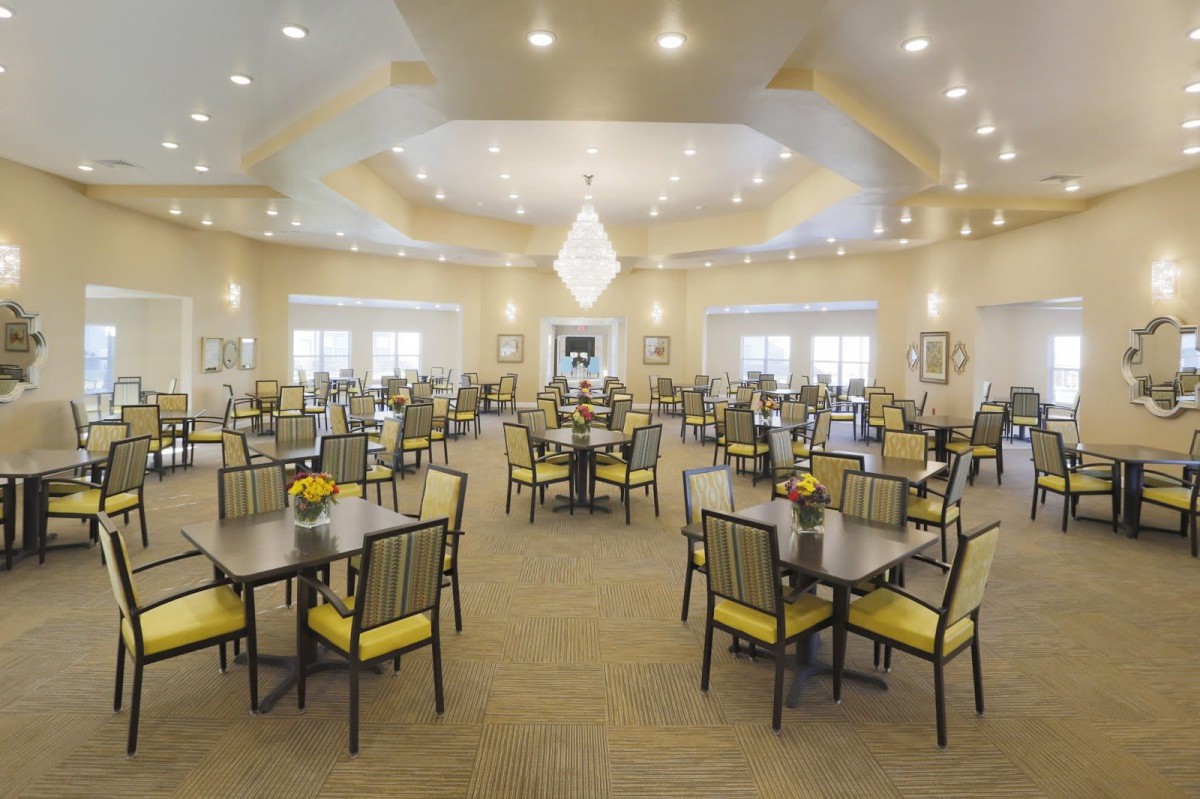 A spacious and well-lit dining hall with neatly arranged tables and chairs.