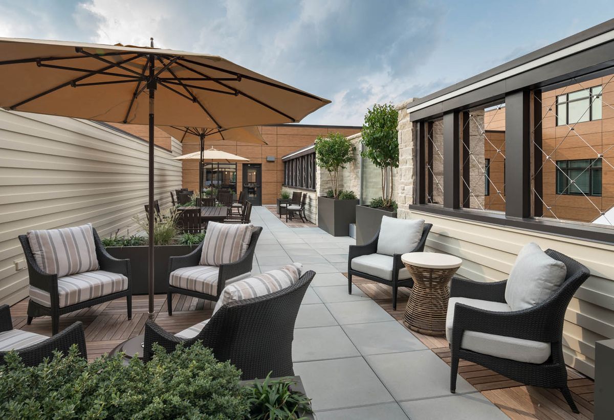 A modern outdoor patio with comfortable seating and umbrellas, perfect for relaxation.