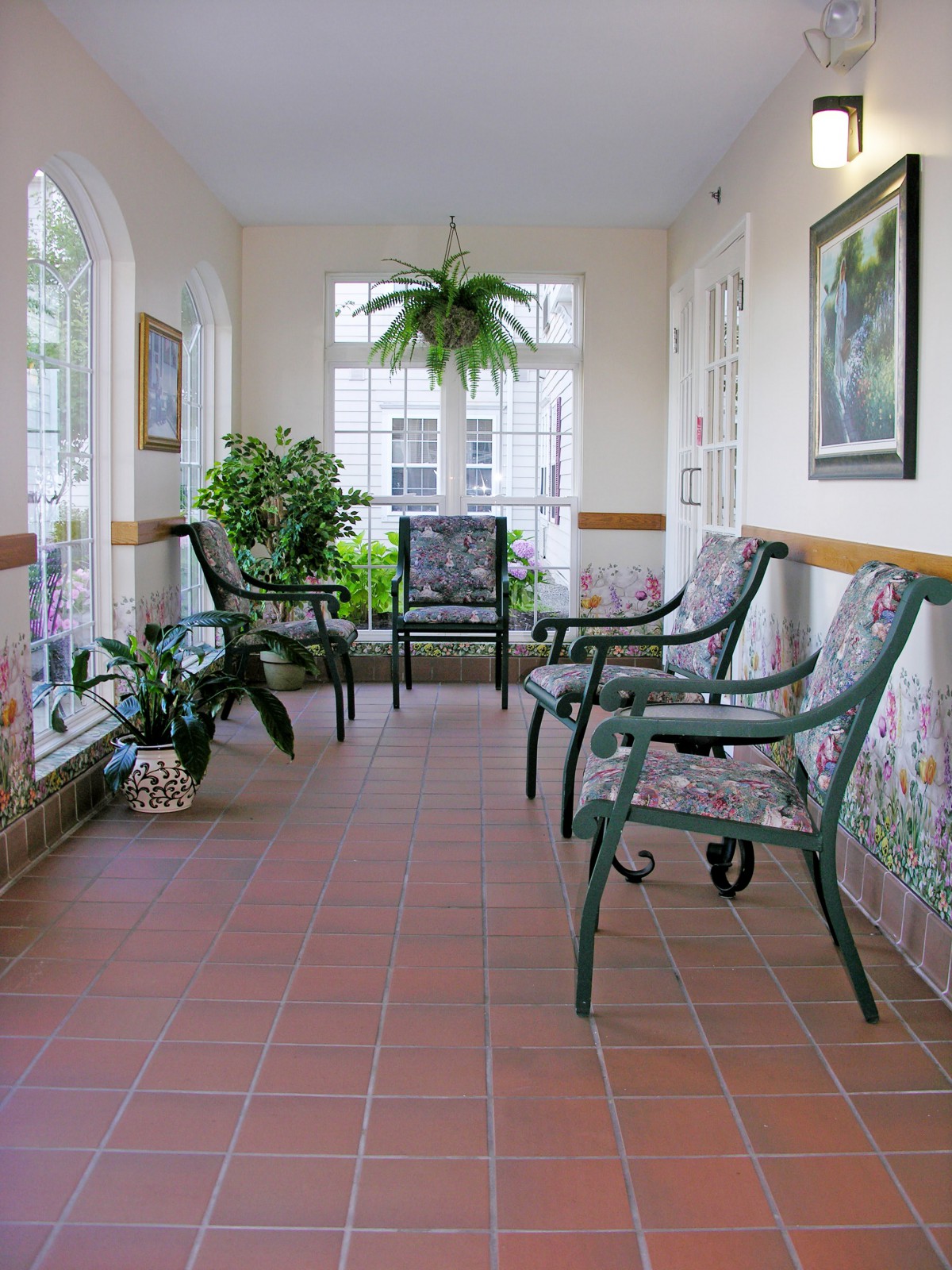 A sunlit waiting room with chairs and plants.