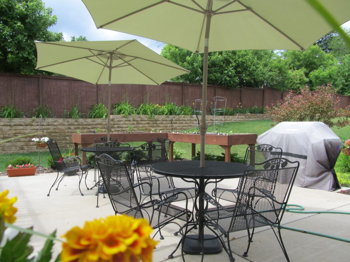 A cozy outdoor patio area with tables and chairs under large umbrellas.