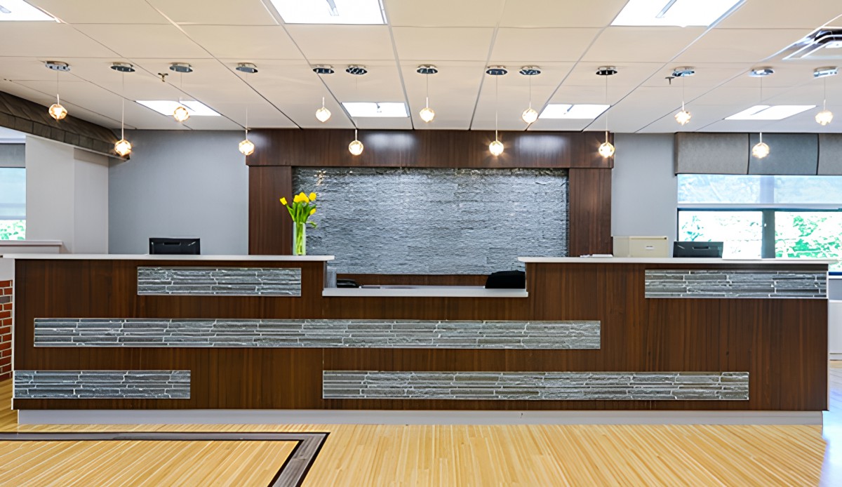 A modern office reception area with wood paneling and contemporary lighting.