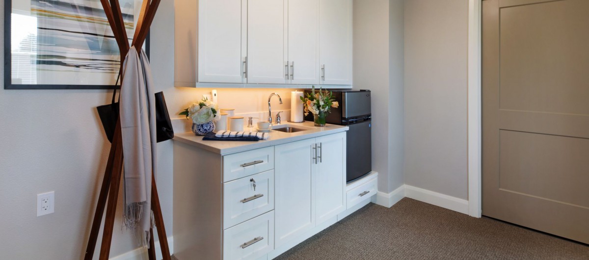 A small modern kitchen with white cabinets and a compact sink area.