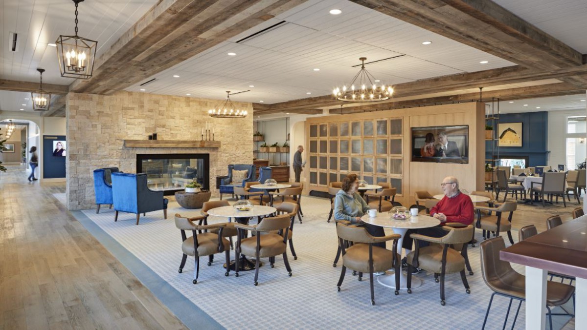 A cozy cafe interior with a fireplace, comfortable seating, and warm lighting.