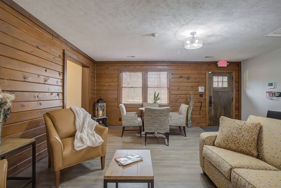 A cozy living room featuring wood paneling and comfortable seating.