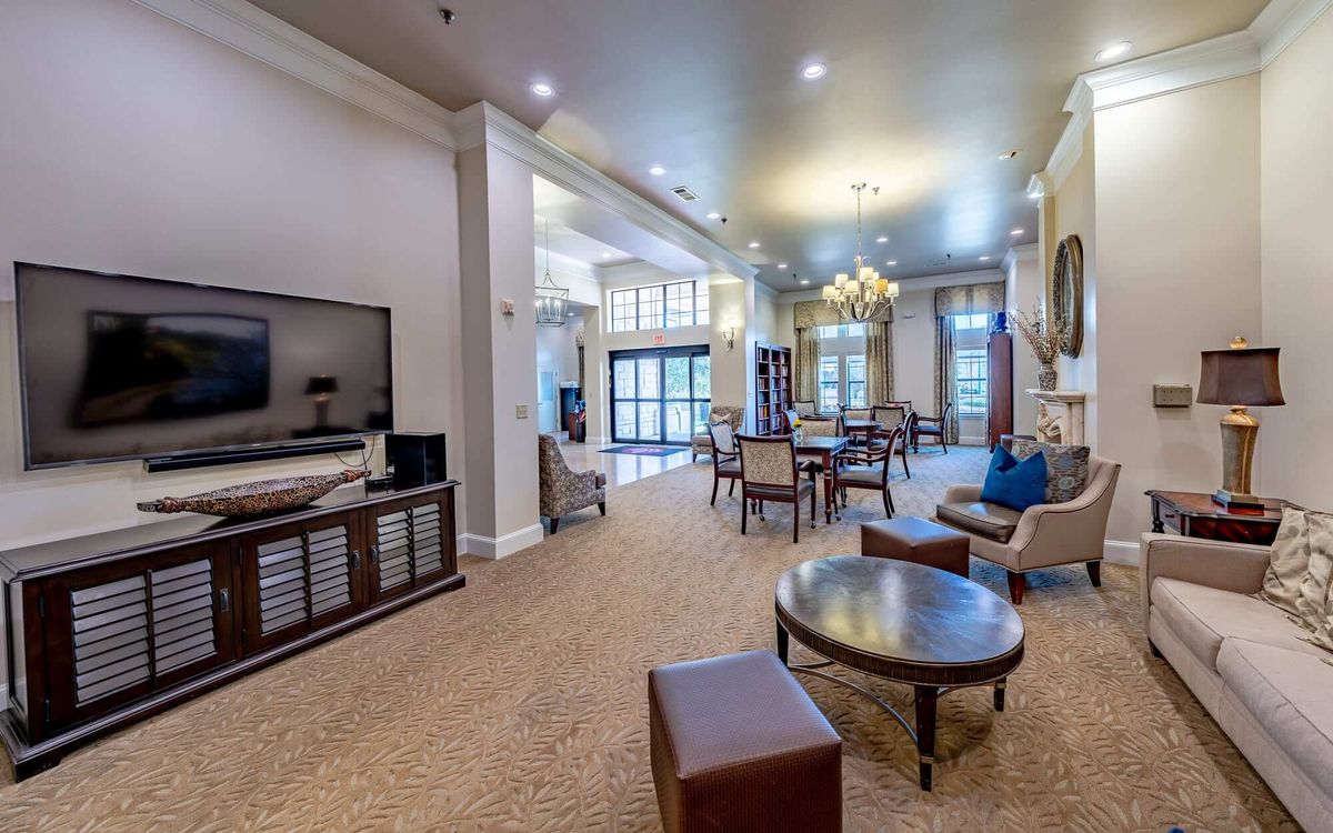 Spacious and elegantly furnished living room with comfortable seating and a large TV.