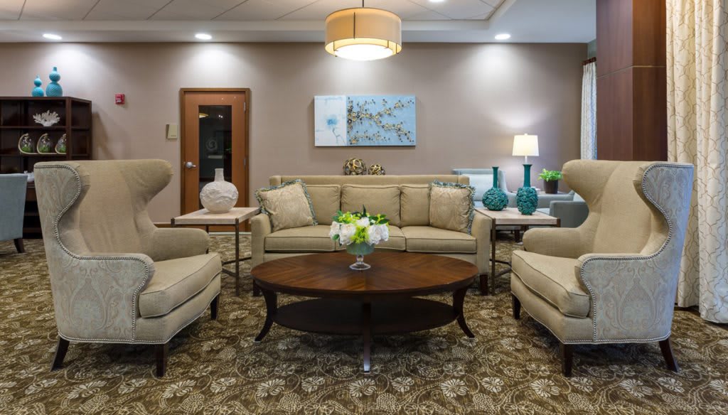 A cozy and elegantly decorated living room with beige sofas, a wooden coffee table, and stylish lighting.