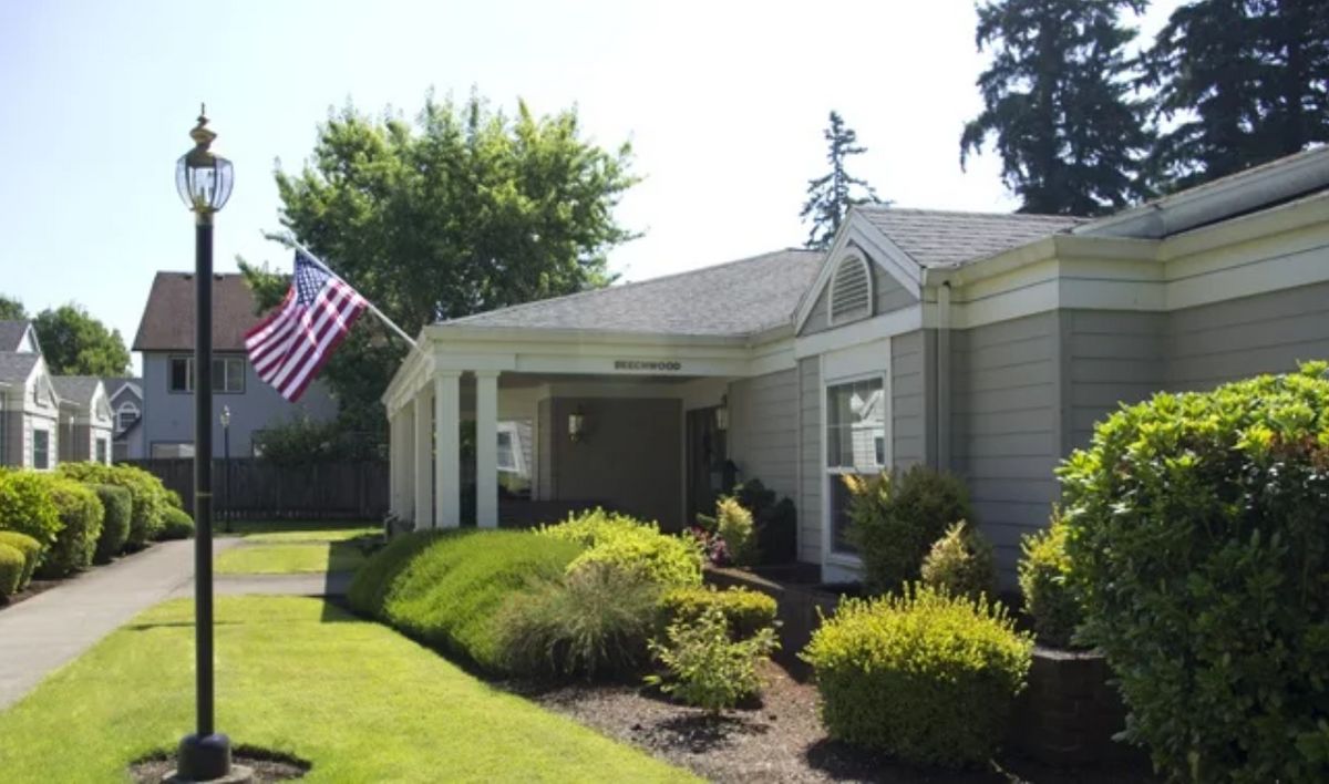 A suburban house with a well-maintained garden and an American flag.