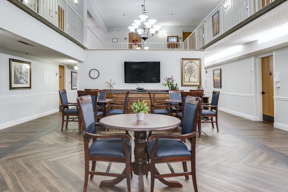 A modern dining area with elegant wooden furniture and a large television.