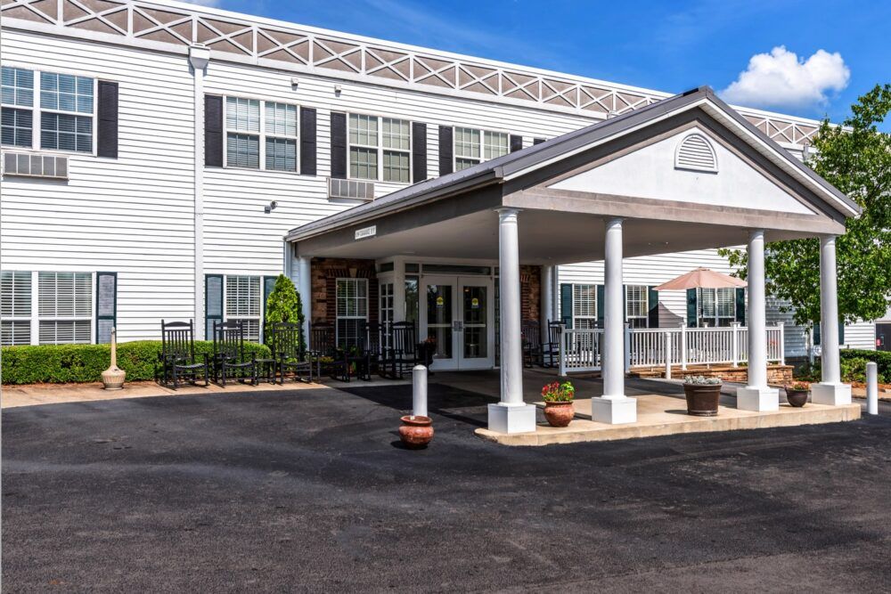 A front entrance of a building with columns and a covered porch.