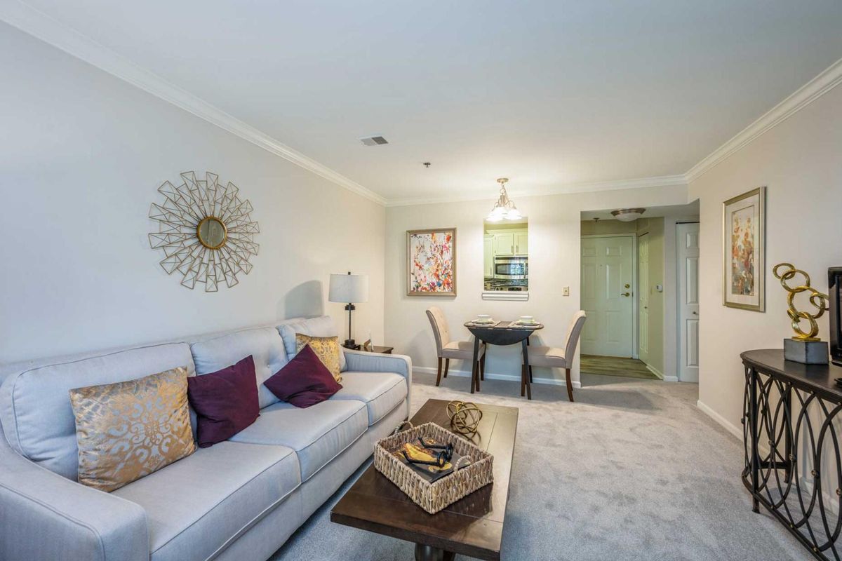 A modern living room with a comfortable sofa, stylish decor, and a cozy dining area.