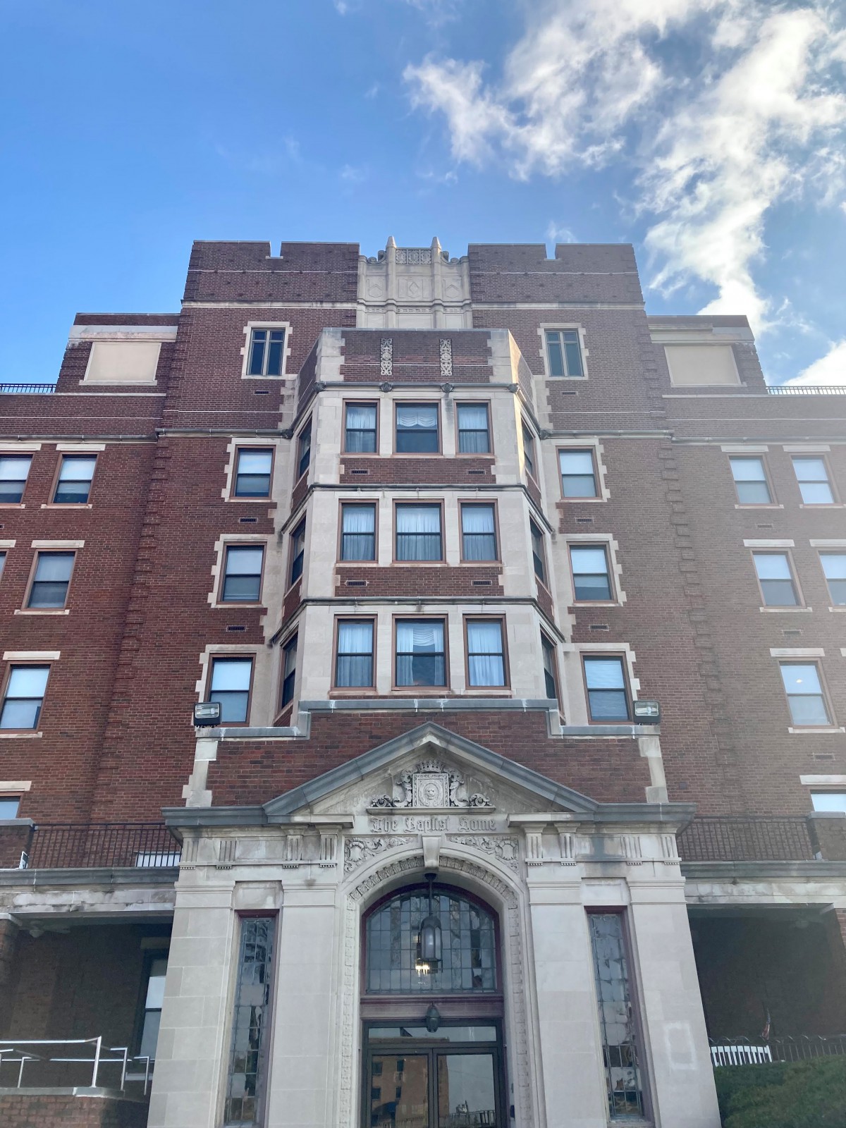 A historic brick building with multiple windows against a blue sky.